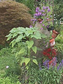 Kunstvoll gebauter Blumenturm mitten im Garten